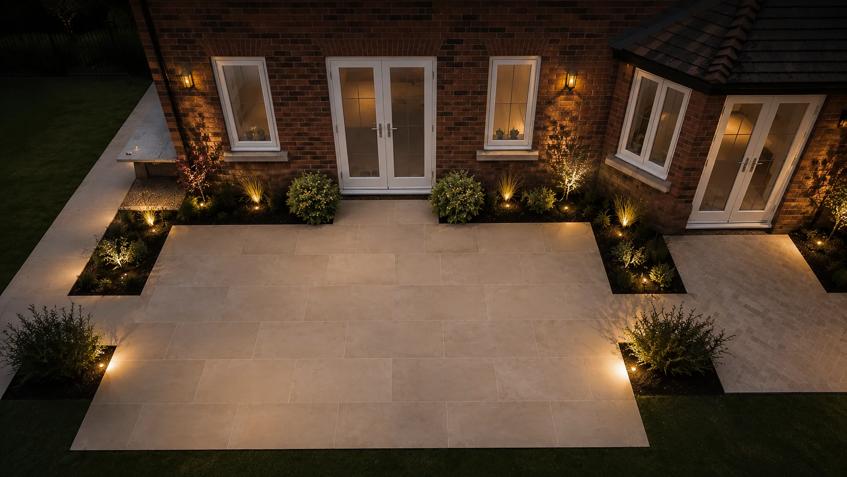 Beautifully lit porcelain patio and garden design at night